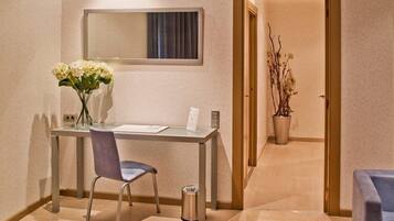 Ein Hotelzimmer mit Schreibtisch, Stuhl und einem Blumenstrauß.