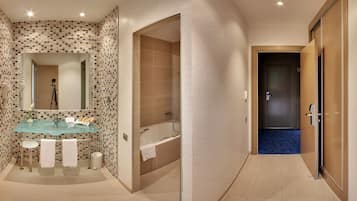 Un baño moderno con un lavabo de vidrio, una bañera y una ducha.