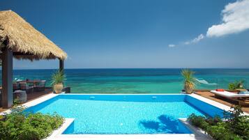 Una piscina al aire libre de temporada, sombrillas