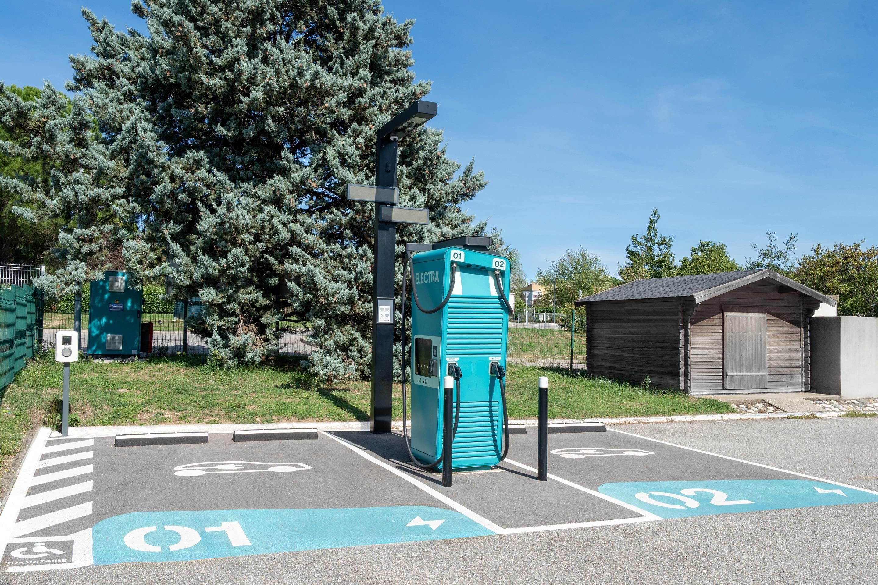 A parking area with electric vehicle charging stations marked as 01 and 02.
