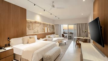 A modern hotel room with a large bed, a desk, a chair, and a TV.