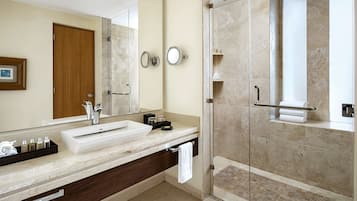 Een moderne badkamer met een grote spiegel, een wastafel en een douche.
