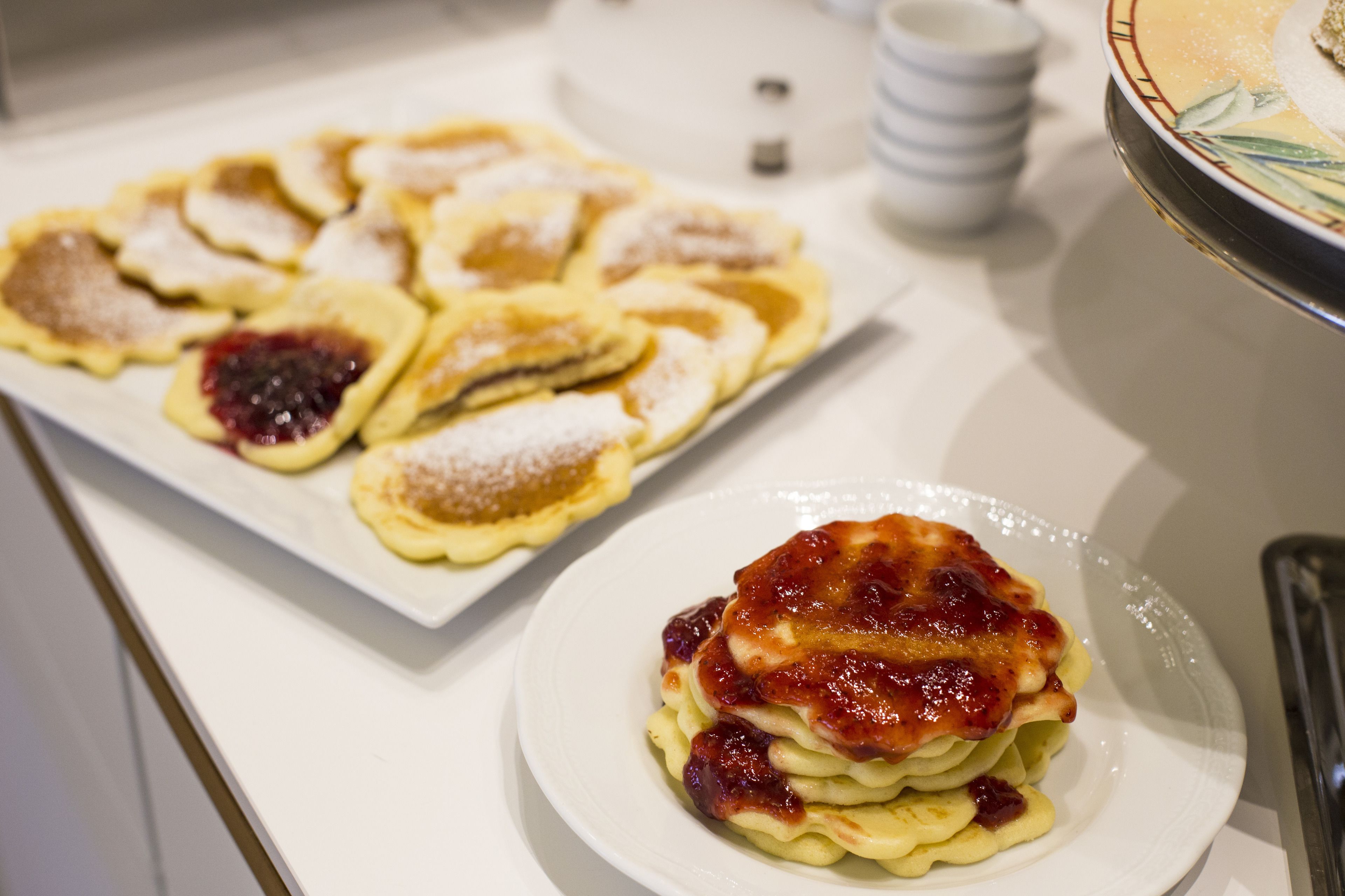 Variedad de pasteles en un plato blanco, algunos con fruta y azúcar glas.