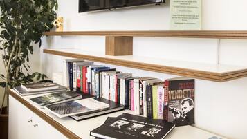A bookshelf with various books, a plant, and a sign with text.