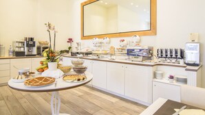 Un bufé de desayuno con diferentes opciones de comida, una estación de café y un espejo grande en la pared.