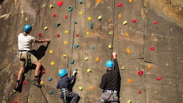 Una pared de escalada con varias rutas y equipo de seguridad.