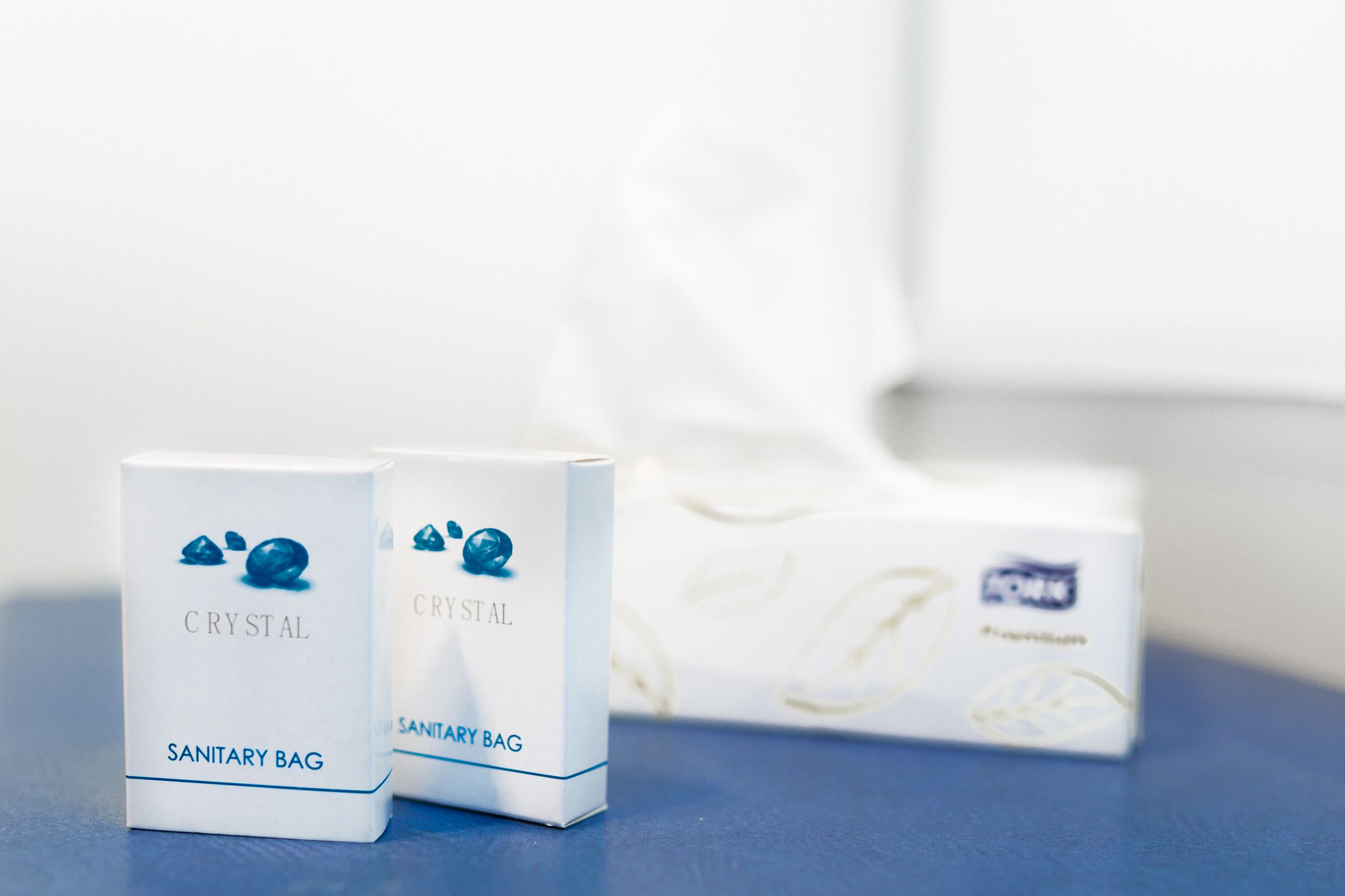 Two sanitary bags and a box with a floral pattern.