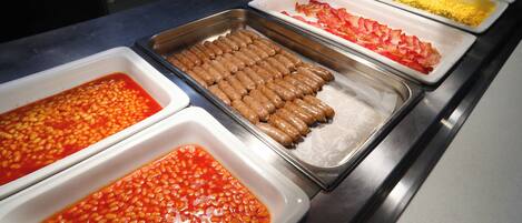 A buffet with various food options including beans, sausages, and other dishes.