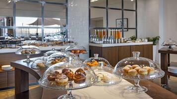 Ein Buffet mit verschiedenen Gebäcksorten und Desserts auf Glasplatten.