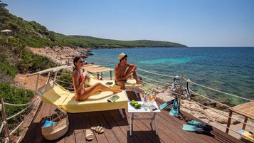 On the beach, black sand, sun-loungers, beach umbrellas