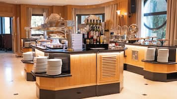 Un buffet d’hôtel avec un îlot central, plusieurs points de service et une grande variété de plats et de boissons.