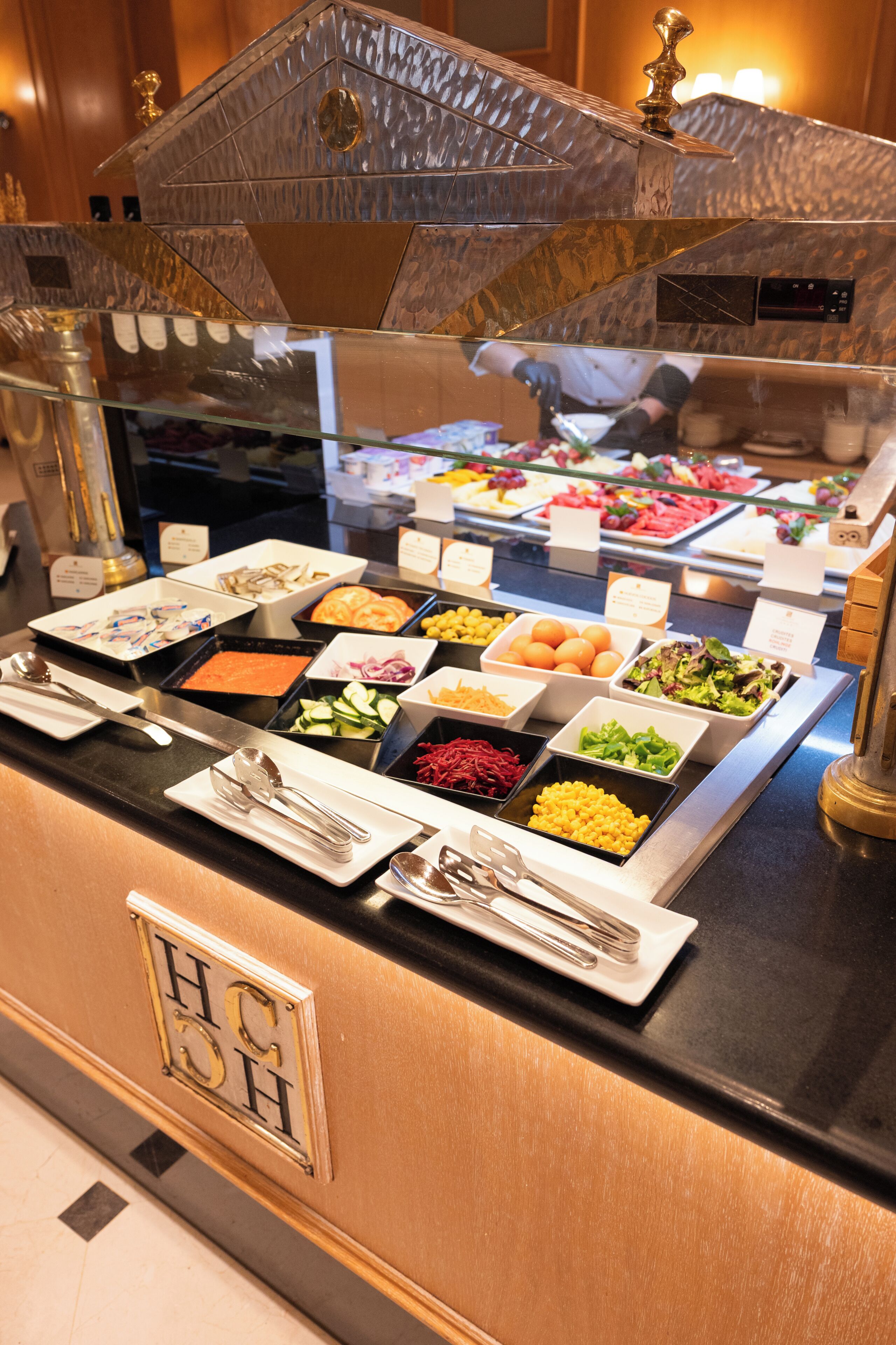 A buffet with various food items and utensils.