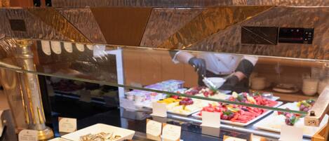A buffet with various food items and utensils.