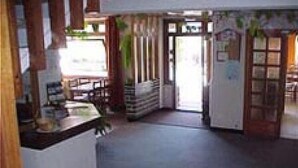 A spacious kitchen with a central island, a dining area with a table and chairs, and a refrigerator. - Hôtel Les Fleurs (Morzine)