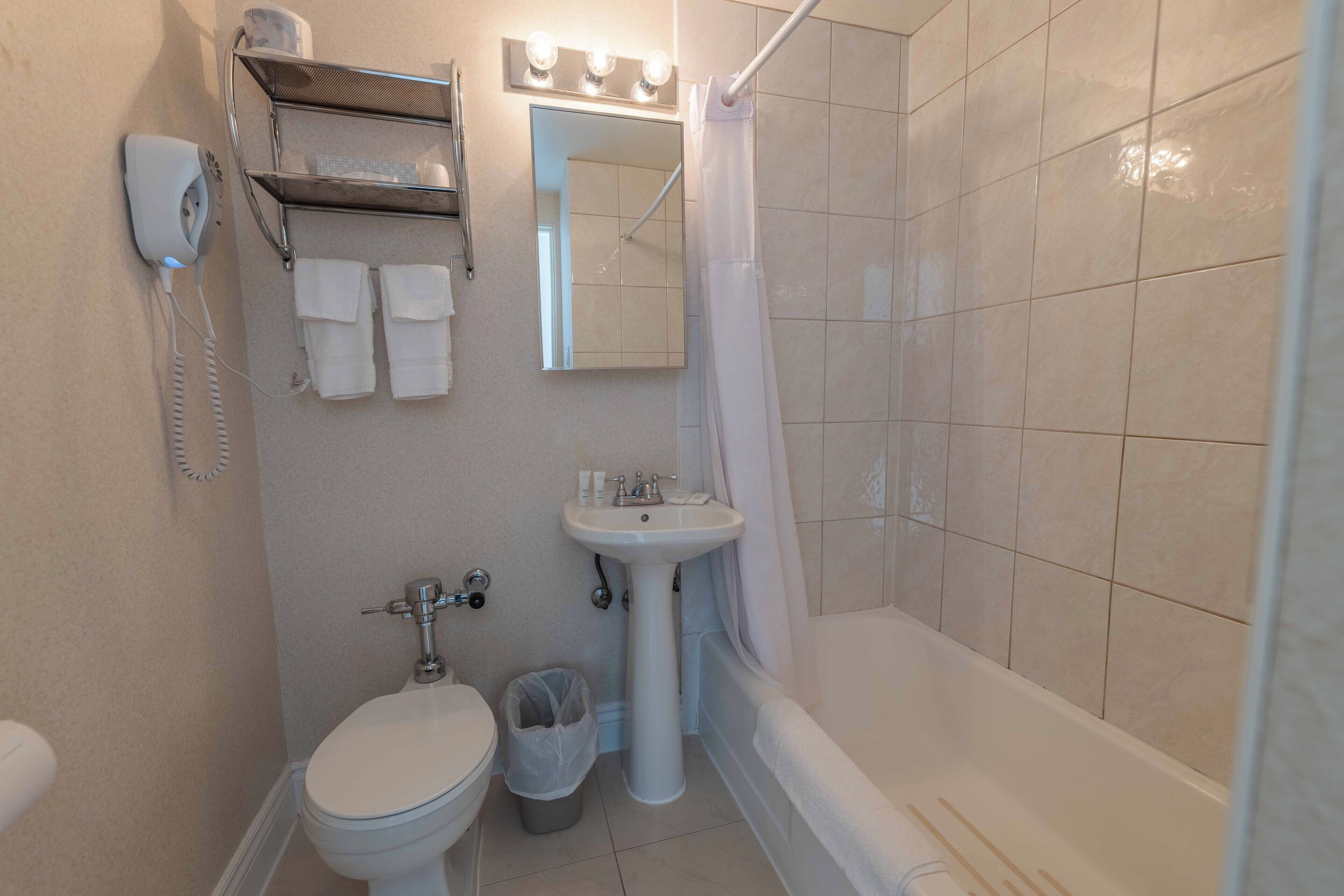 A bathroom with a toilet, sink, and bathtub.