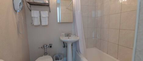 A bathroom with a toilet, sink, and bathtub.