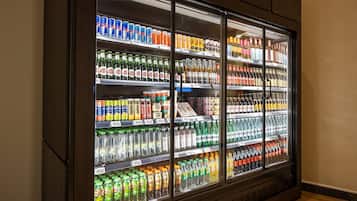 Vitrine refrigerada repleta de diversas bebidas, incluindo refrigerantes, sucos e bebidas alcoólicas.