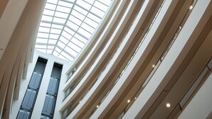 A multi-level atrium with a glass ceiling and multiple floors. - Crowne Plaza Brussels Airport by IHG (Machelen)