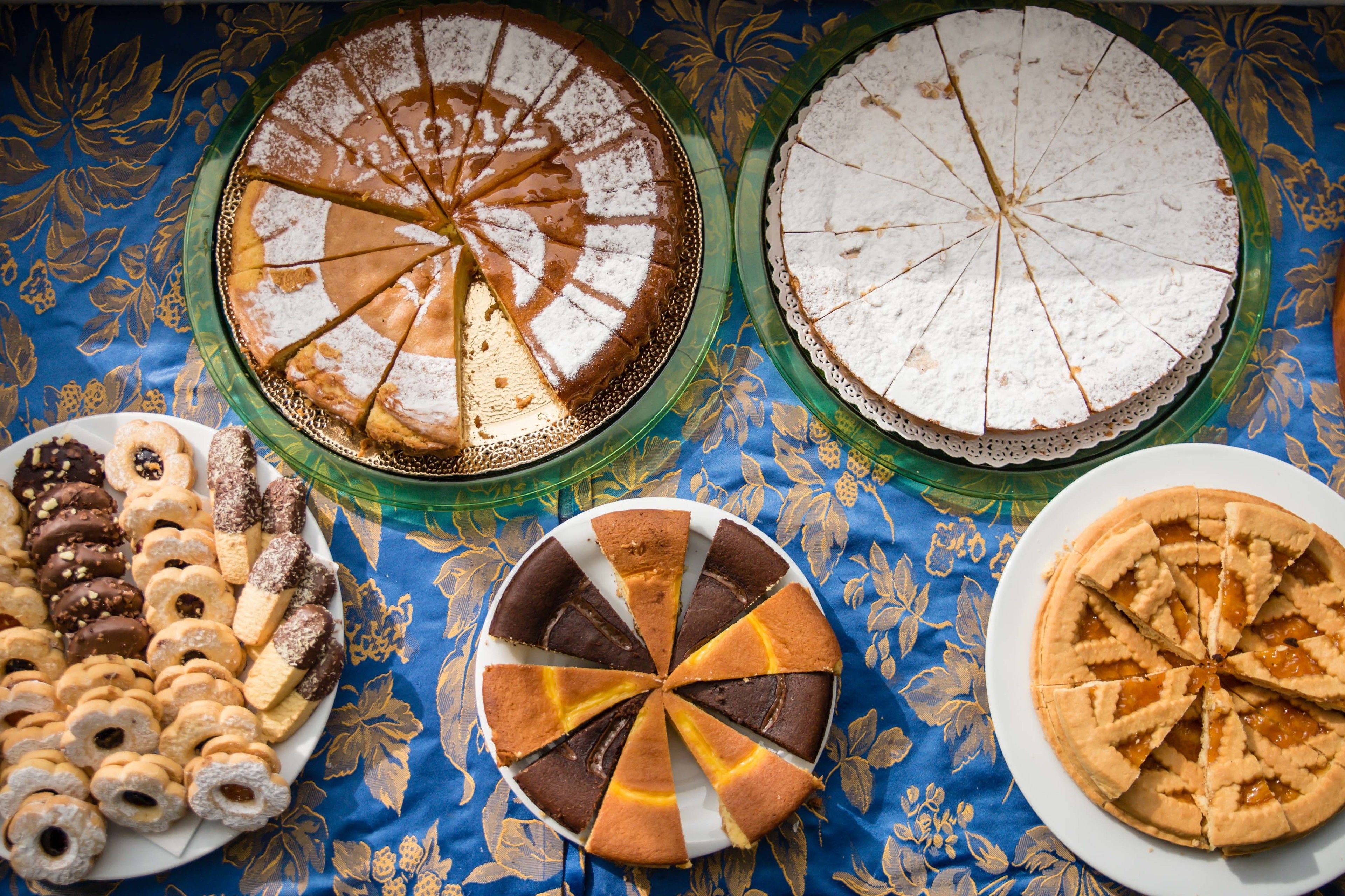 Three pies on plates with a blue tablecloth.