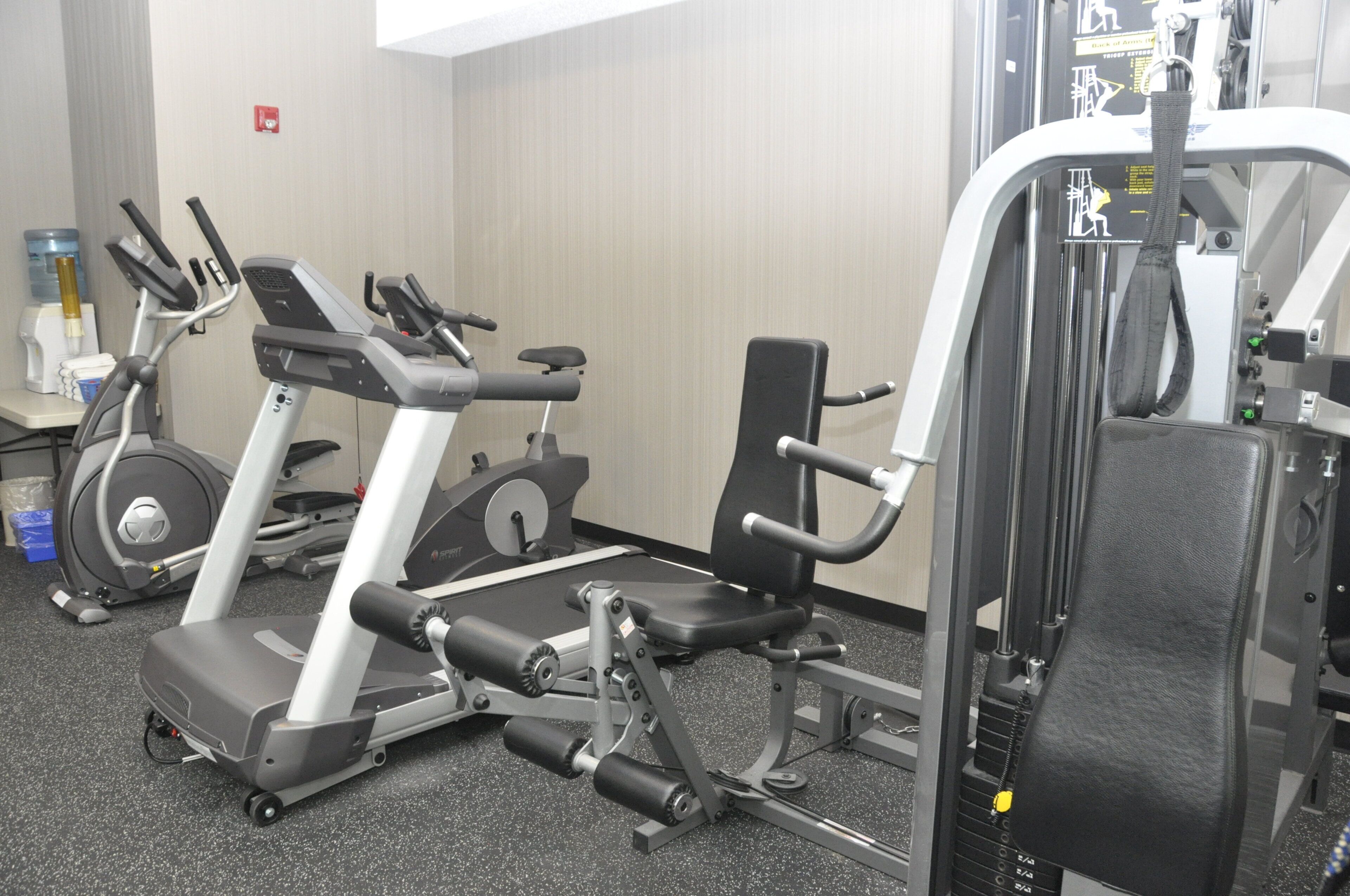 A gym with cardio machines, weightlifting equipment, and a water dispenser.