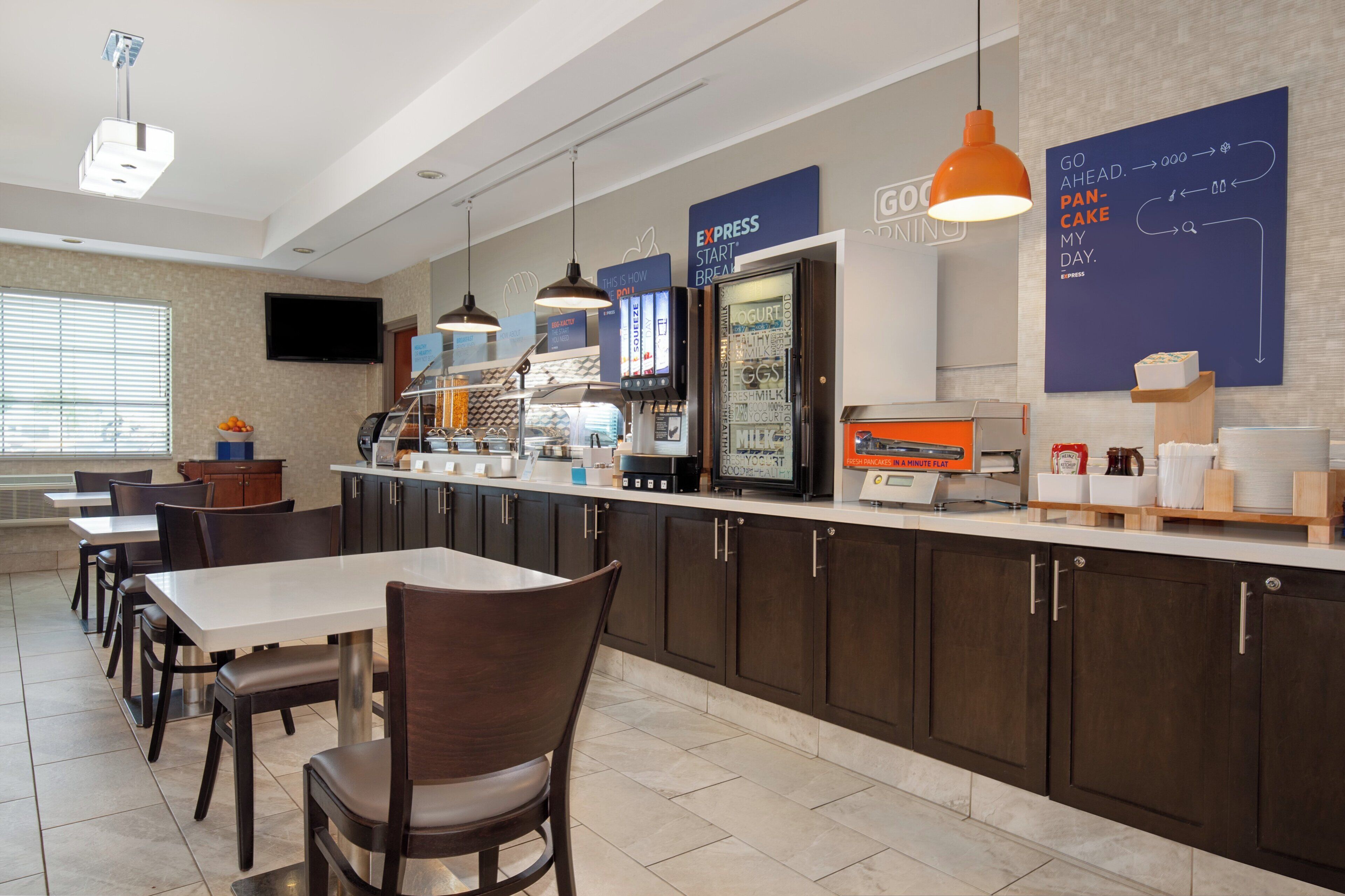 A breakfast area with a counter, seating, and a television.