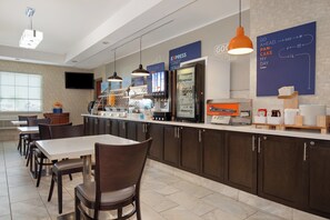 A breakfast area with a counter, seating, and a television. - Holiday Inn Express Hotel & Suites Barrie by IHG (Barrie)