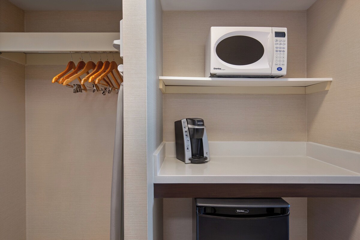 A kitchenette with a microwave, coffee maker, and a dishwasher.