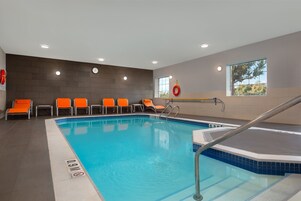 Una piscina techada, sillones reclinables de piscina