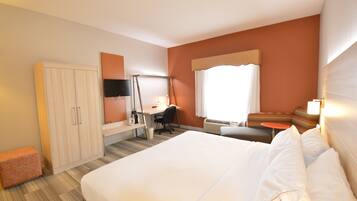 Une chambre d’hôtel équipée d’un lit, d’un bureau, d’une chaise, d’une armoire et d’un téléviseur.