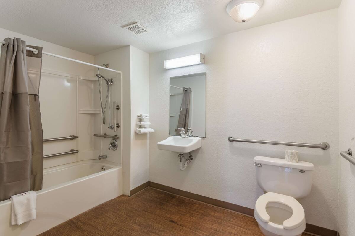 Un baño con bañera, lavamanos, inodoro y ducha.