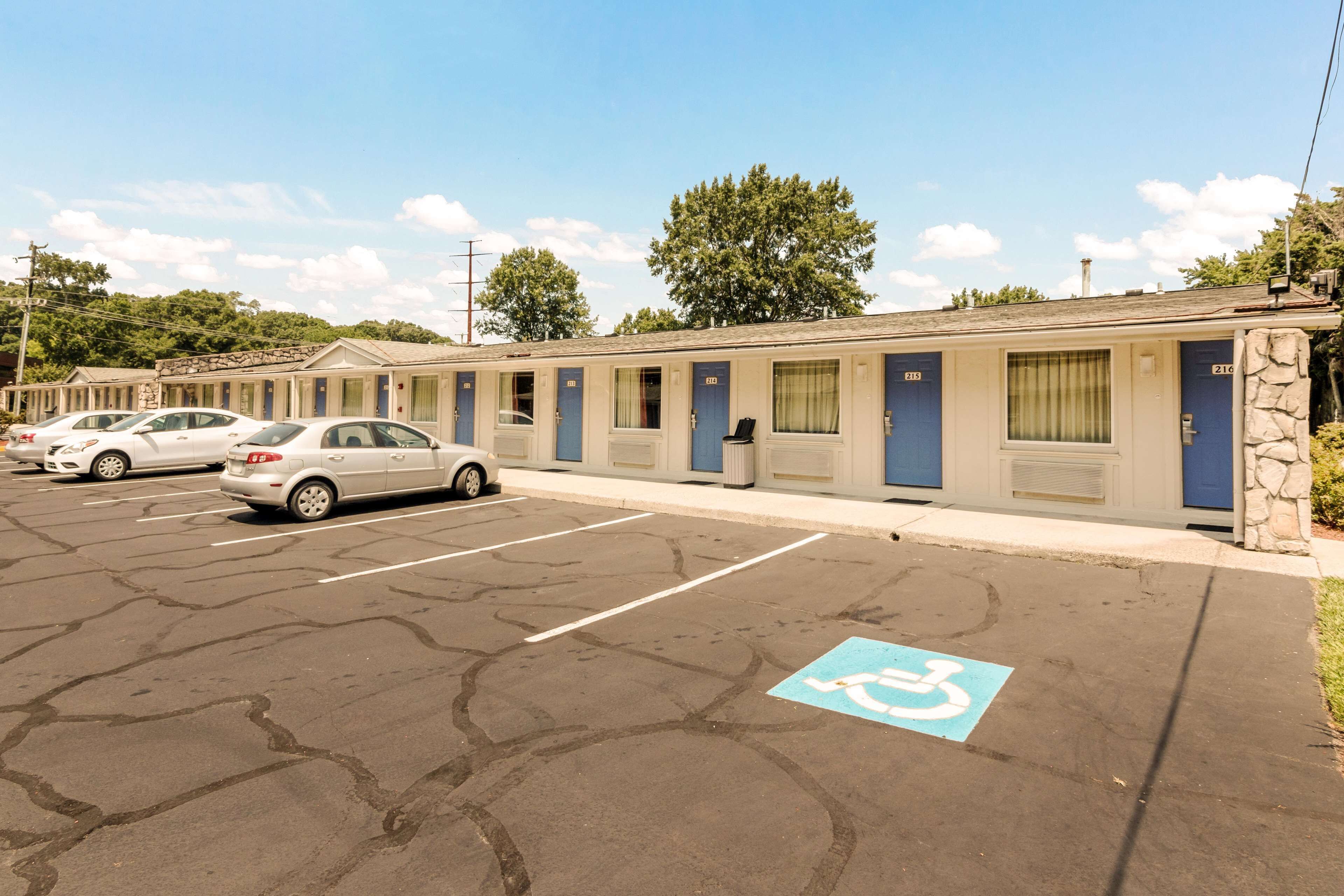 A motel with multiple rooms, a parking lot, and a handicapped parking space.