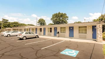 A motel with multiple rooms, a parking lot, and a handicapped parking space.