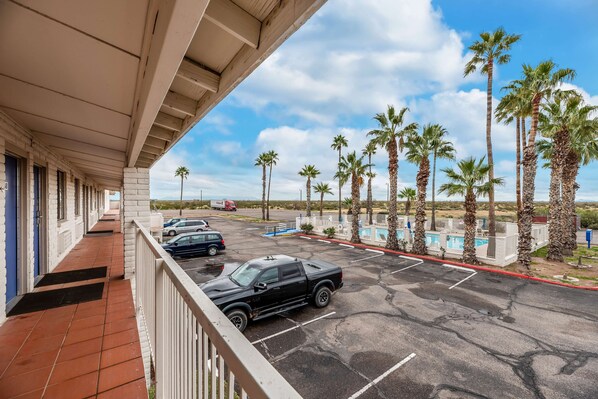 A hotel balcony with a view of parked cars and palm trees. - Motel 6 Eloy, AZ - Casa Grande (Eloy)