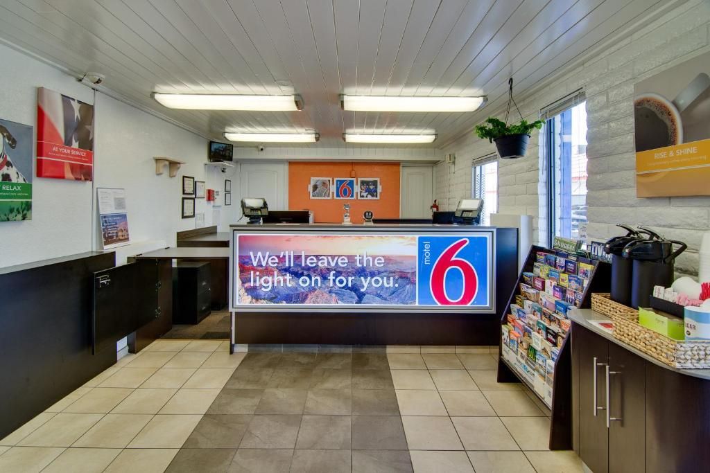 Un espace d’accueil comprenant un comptoir, un écran numérique et une fenêtre donnant sur un paysage agréable.