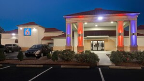 A hotel with a '6' sign, a covered entrance, and a parking lot. - Motel 6 Shepherdsville, KY – Louisville South (Shepherdsville)