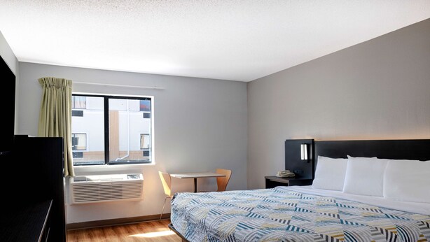 A hotel room with a large bed, a desk, a chair, and a window with curtains. - Motel 6 Shepherdsville, KY – Louisville South (Shepherdsville)