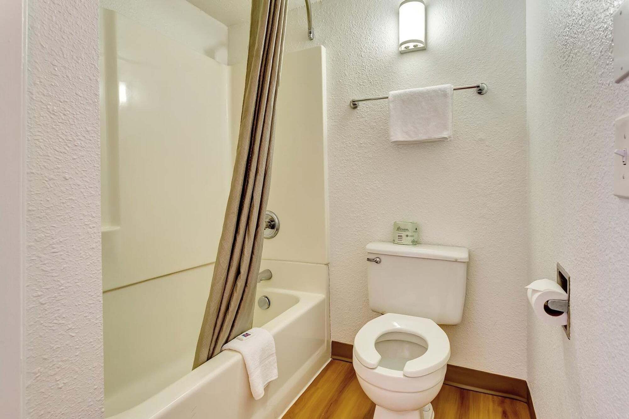 Ein Badezimmer mit Badewanne, Toilette und Duschvorhang.