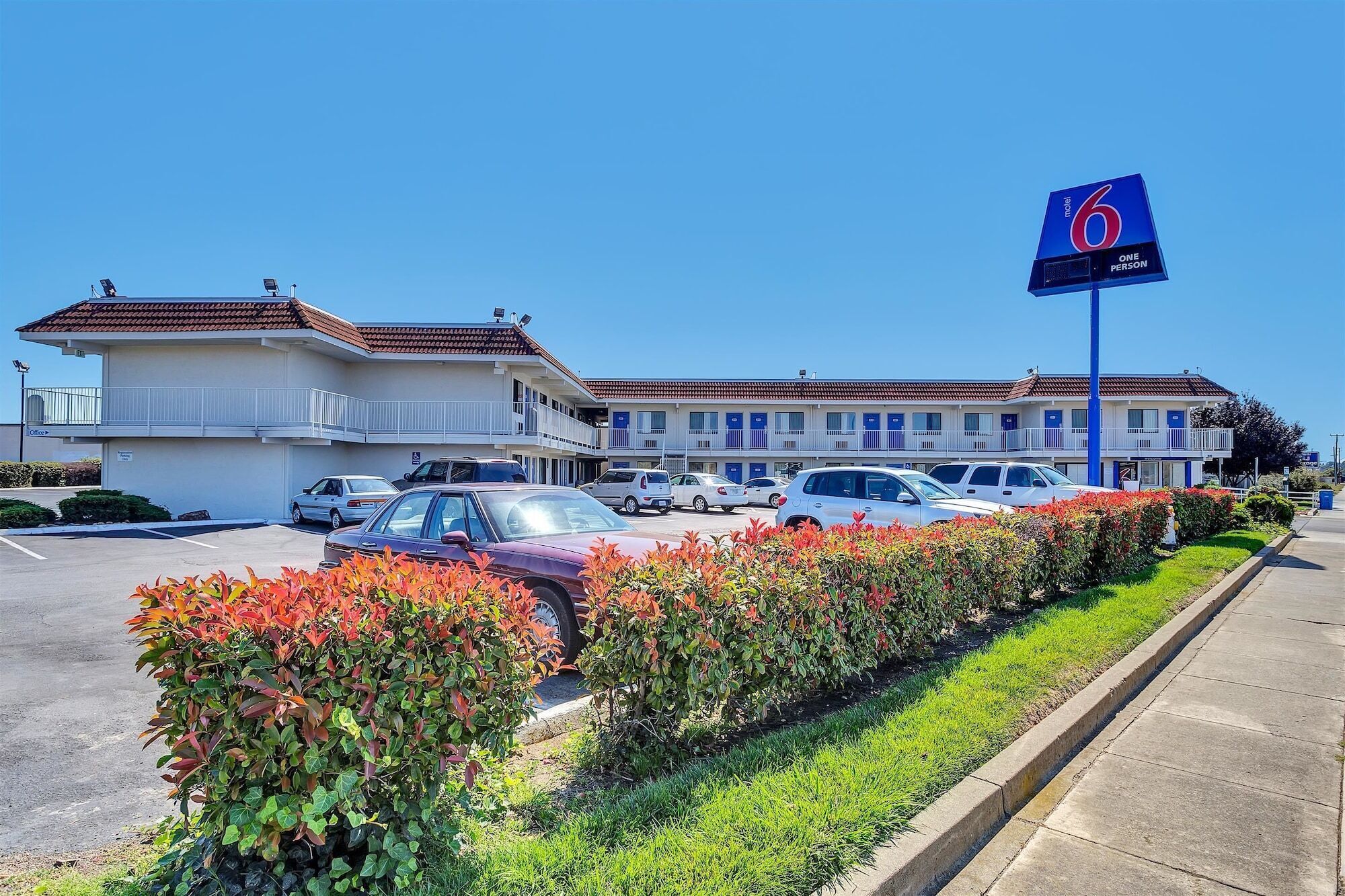 A motel with a large sign indicating it is a '6 person' motel.