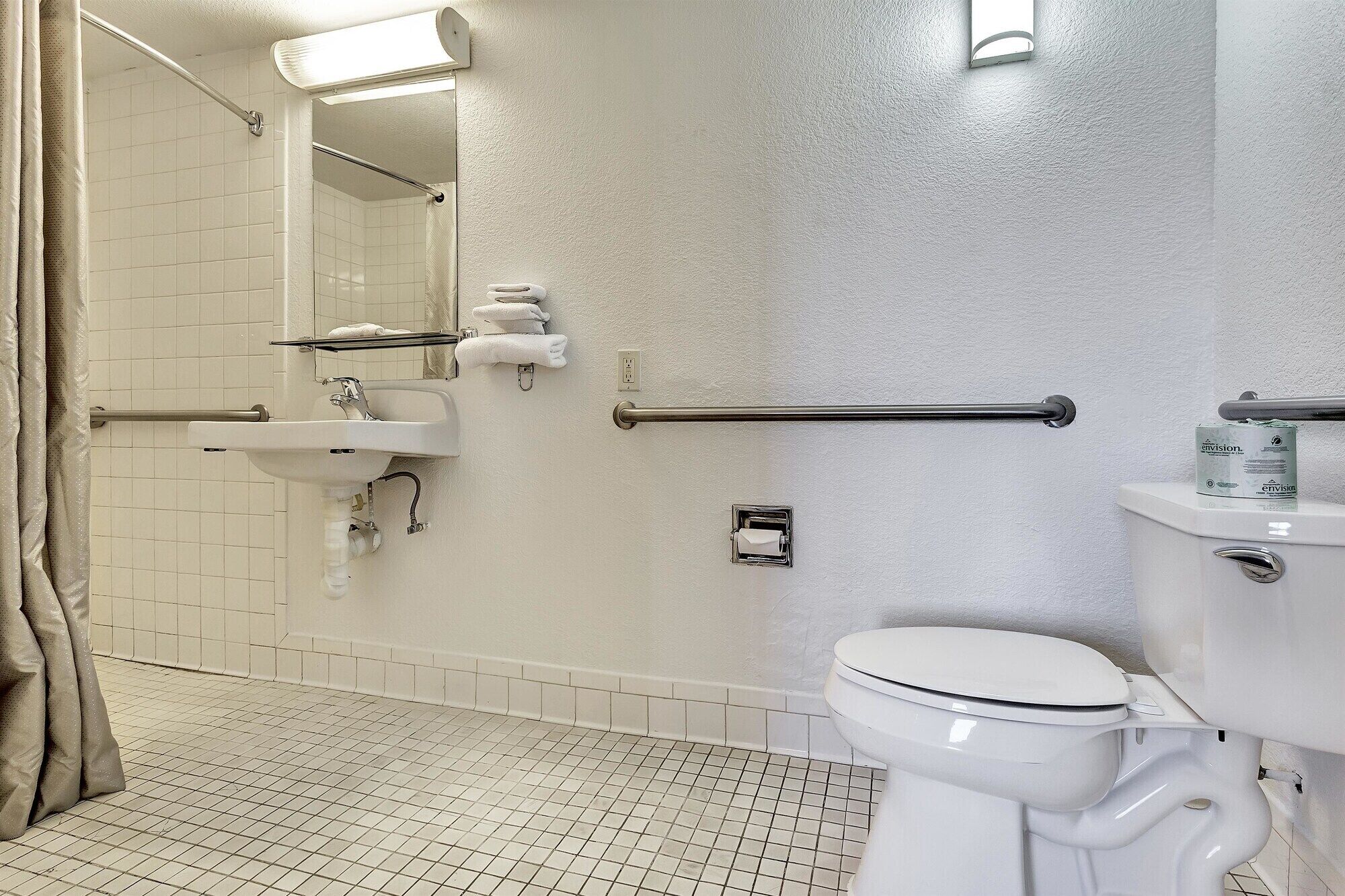 A bathroom with a shower, toilet, and sink.