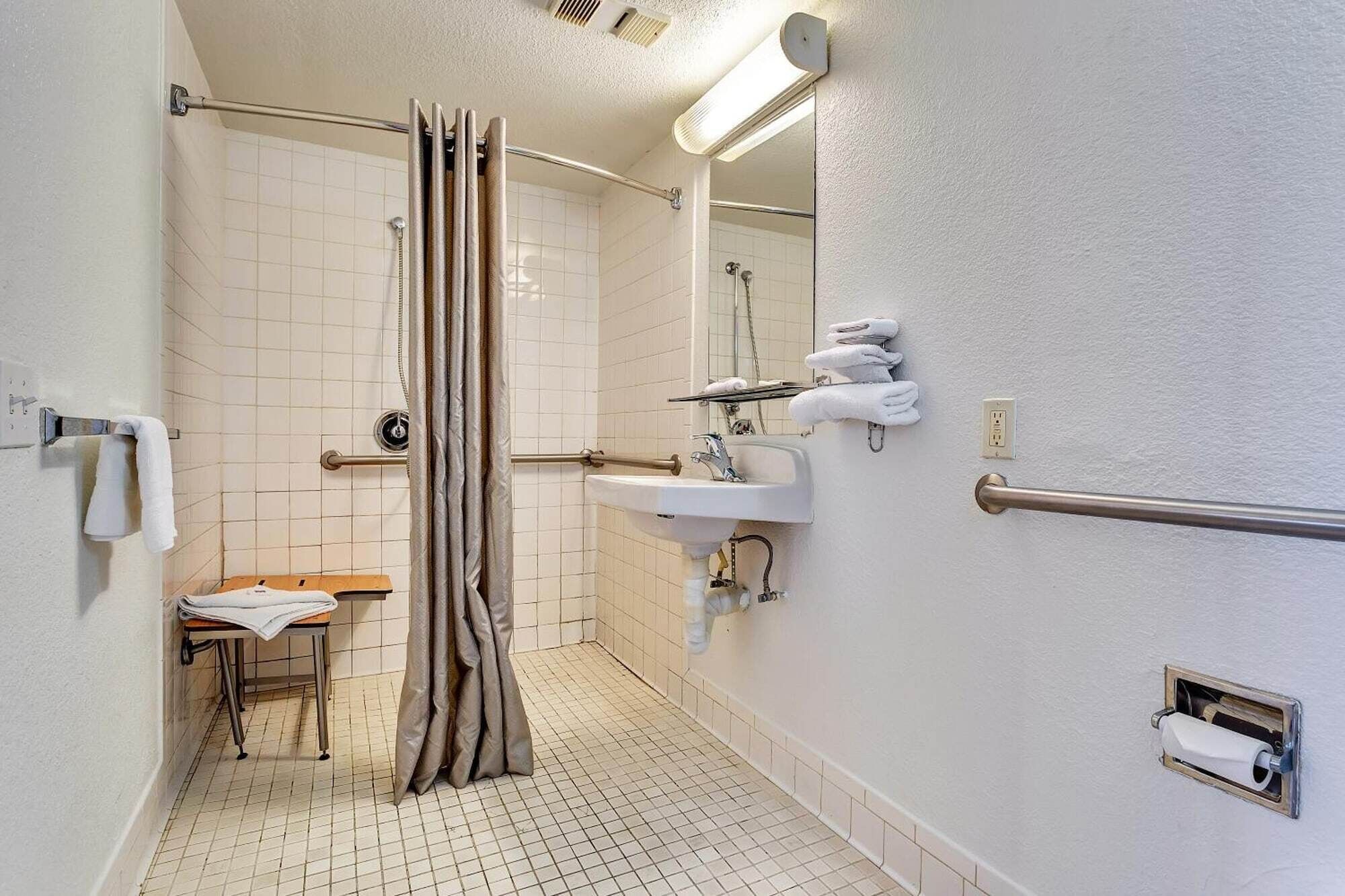 A bathroom with a shower, sink, and toilet.