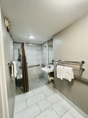 A modern bathroom with a shower, toilet, and sink.