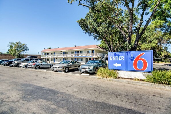 A motel with a red roof and a sign indicating an entrance to room 6. - Motel 6 Stockton, CA - North (Stockton)