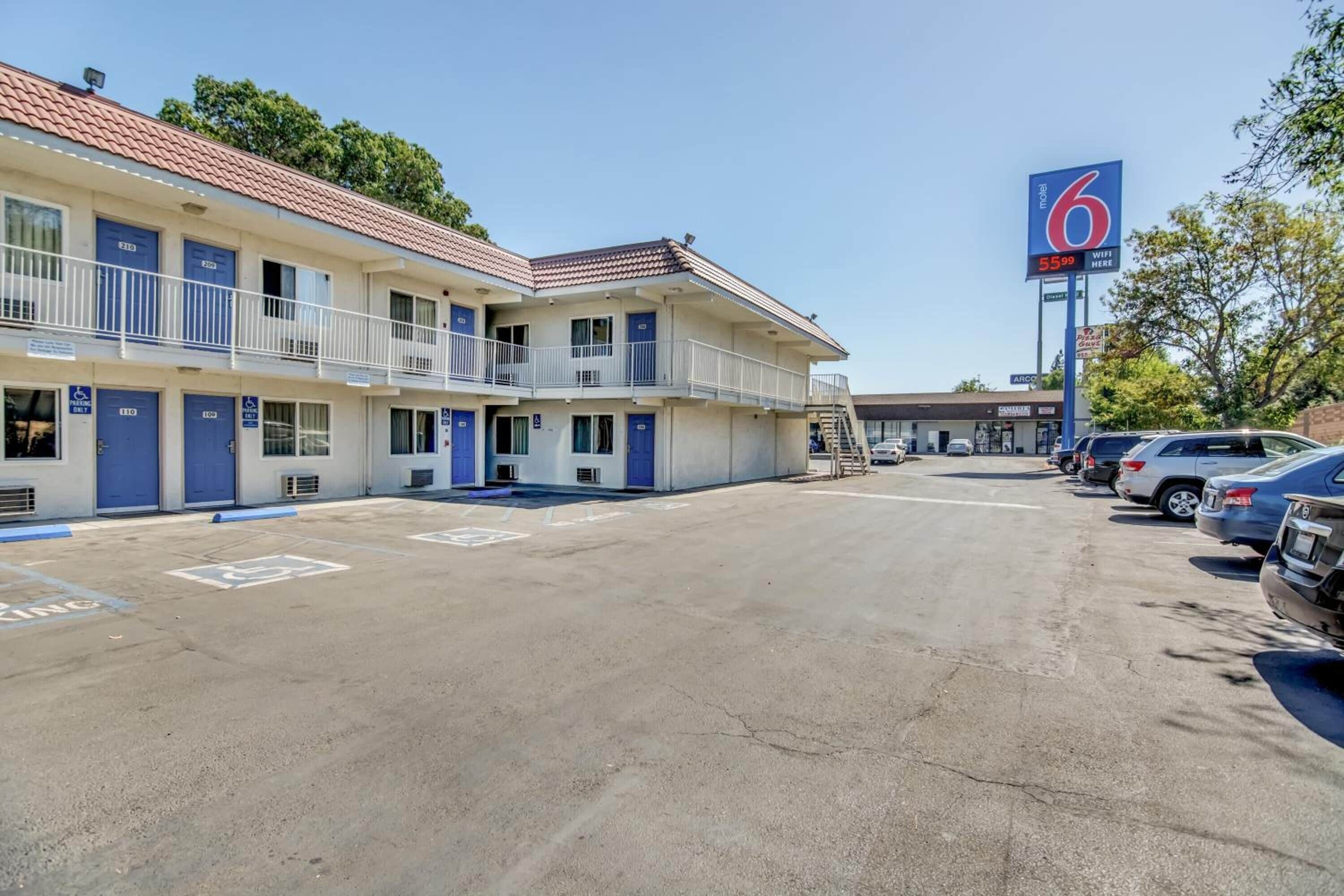 A motel with multiple rooms, a parking lot, and a sign indicating the price.