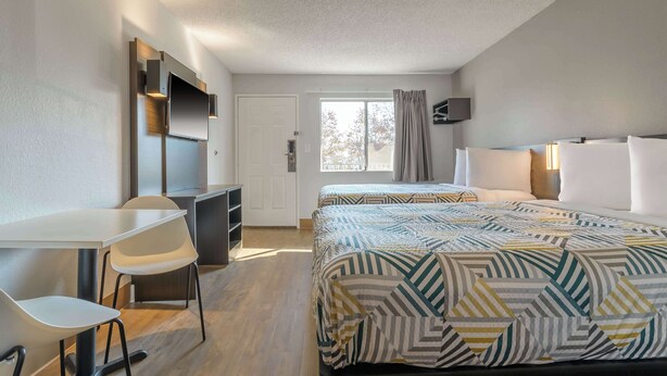 A hotel room with a bed, a desk, a chair, a TV, and a window. - Motel 6 Hayward, CA – Silicon Valley Gateway (Hayward)