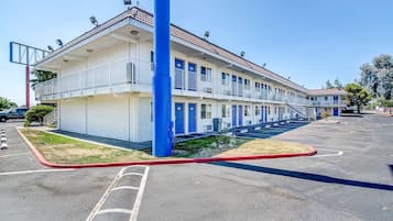 Un motel con struttura a due piani, un parcheggio e una piccola area verde.