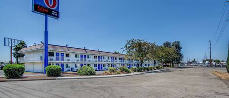 Un motel con un cartel que indica un precio de 55,99 dólares por noche y disponibilidad de Wi-Fi.