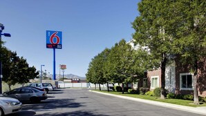A motel with a large blue sign indicating room rates and Wi-Fi availability. - Motel 6 Lehi, UT – Thanksgiving Point (Lehi)