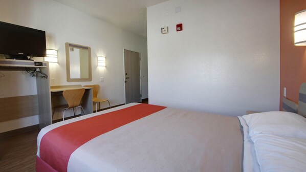 A hotel room with a bed, a desk, a chair, a television, and a mirror. - Motel 6 Lehi, UT – Thanksgiving Point (Lehi)