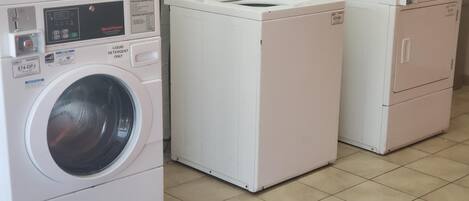 A laundry area with a front-loading washing machine and a stacked dryer.