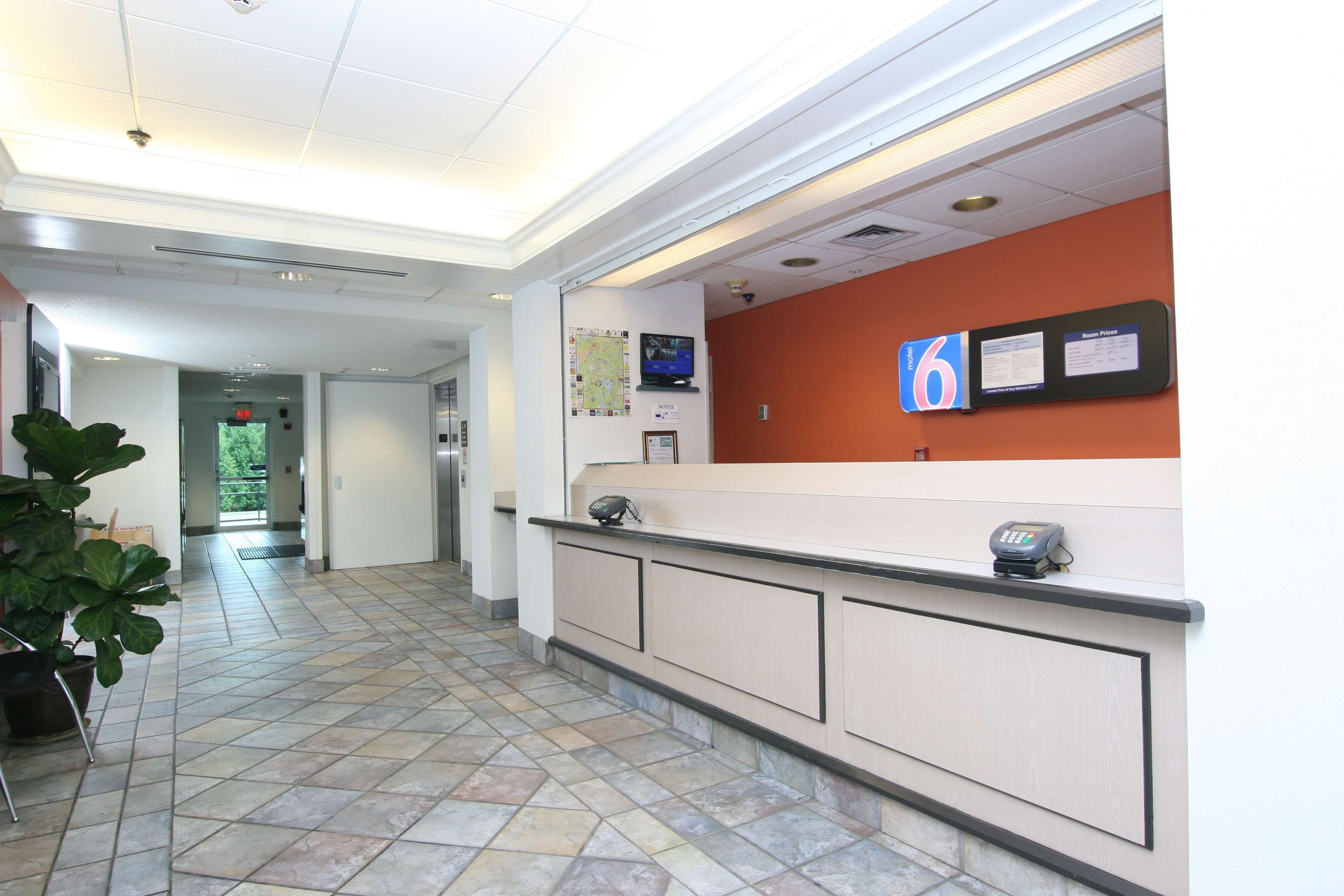 A reception area with a counter, a map, and a digital display.